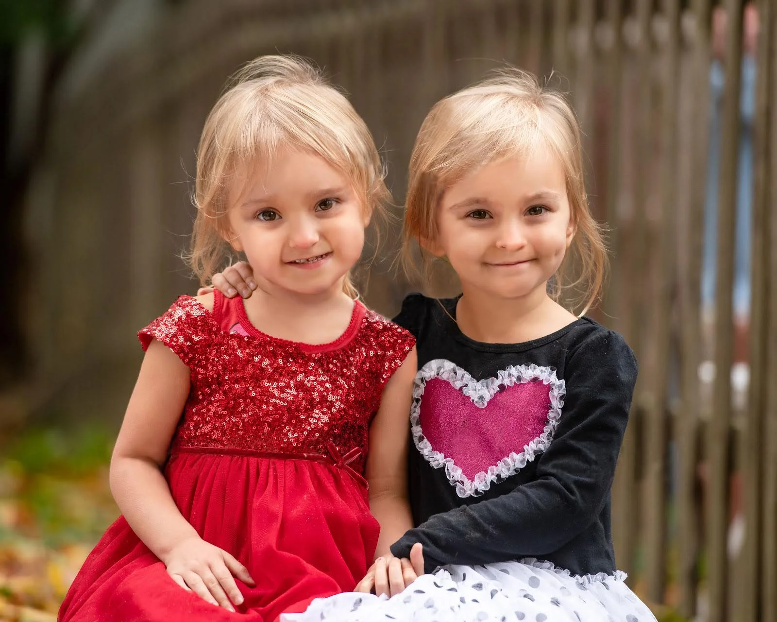 Jaya and Fiona in red dresses, side by side