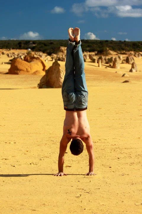 A handstand on the sand among the limestone pillars of the Pinnacles